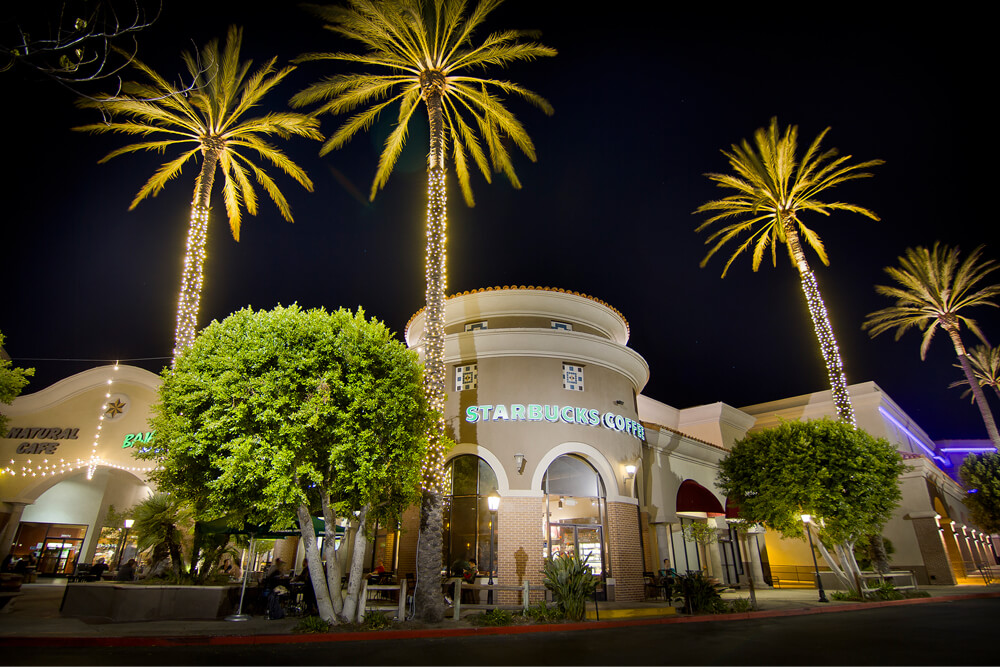 Holiday lighting installation in a commercial plaza with Starbucks